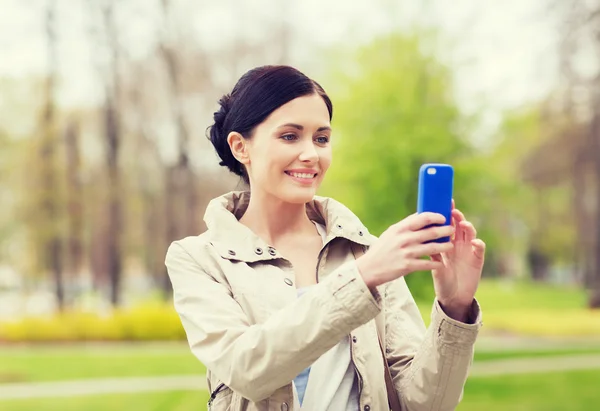 Donna sorridente scattare foto con smartphone — Foto Stock