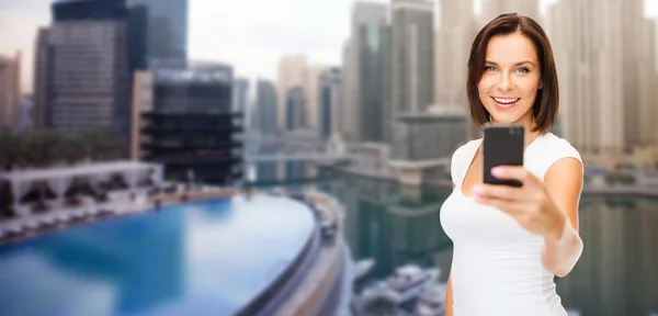 Kvinna med bild av smartphone över dubai city — Stockfoto