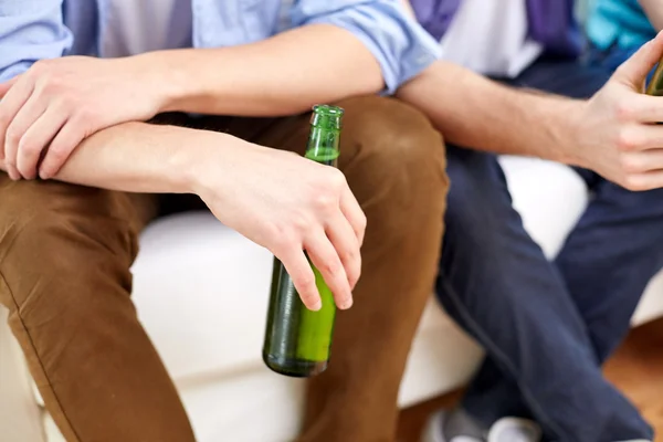 Close up of male friends drinking beer at home — Stock Photo, Image