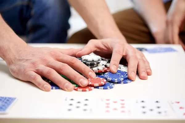 Mãos com fichas de casino fazendo aposta ou ganhando — Fotografia de Stock