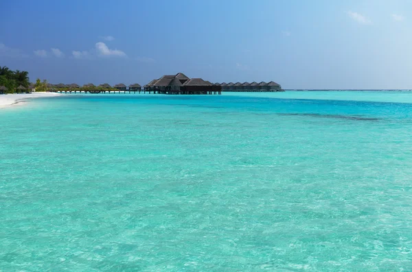 Bungalow cabanes dans l'eau de mer sur la plage de villégiature exotique — Photo