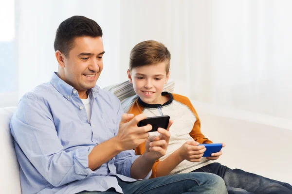 Feliz padre e hijo con smartphones en casa — Foto de Stock