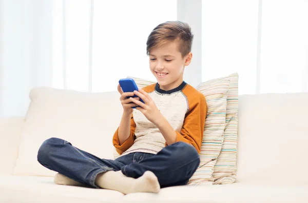 Niño con mensajes de texto de teléfonos inteligentes o jugando en casa — Foto de Stock