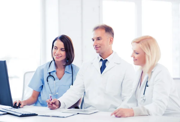 Doctors looking at computer on meeting — Stock Photo, Image