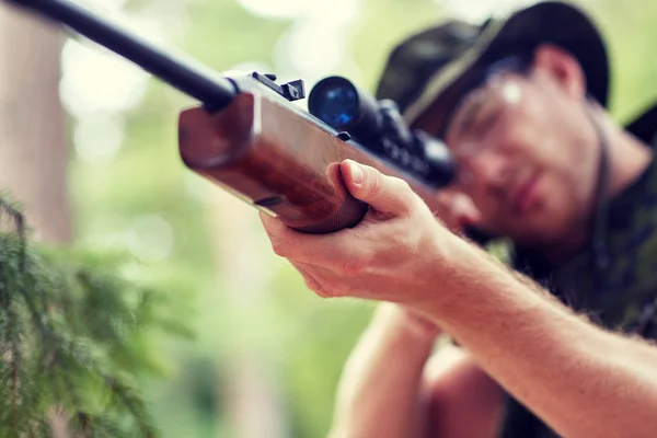 Soldado o cazador disparando con arma en el bosque —  Fotos de Stock