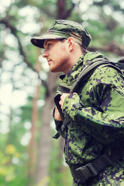 Junger Soldat mit Rucksack im Wald — Stockfoto