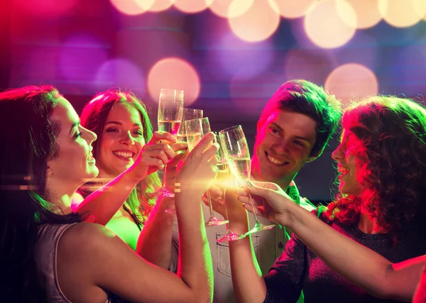 Amigos sonrientes con copas de champán en el club —  Fotos de Stock
