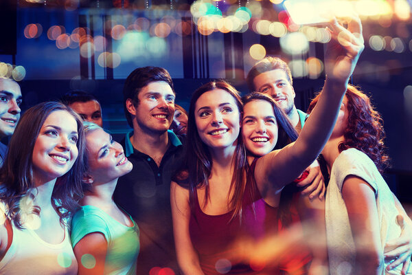 Friends with smartphone taking selfie in club — Stock Photo, Image