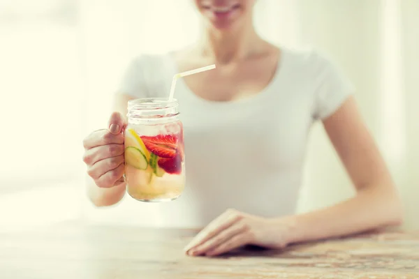 Primer plano de la mujer sosteniendo vidrio con agua de frutas —  Fotos de Stock