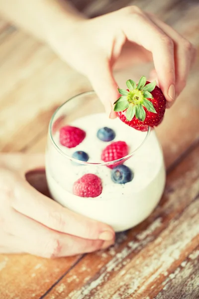 Primer plano de las manos de la mujer con yogur y bayas —  Fotos de Stock