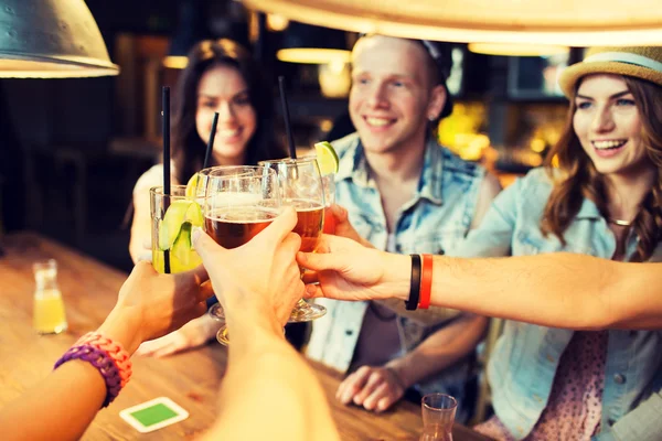 Amigos felizes batendo copos no bar ou pub — Fotografia de Stock