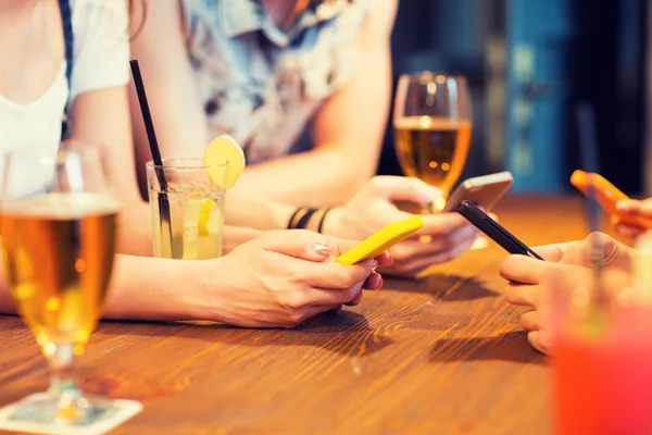 Close up of hands with smartphones at bar — 图库照片