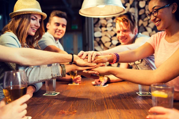 Amigos poniendo las manos uno encima del otro en el bar —  Fotos de Stock