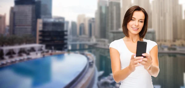 Mujer tomando selfie por teléfono inteligente sobre ciudad de dubai — Foto de Stock