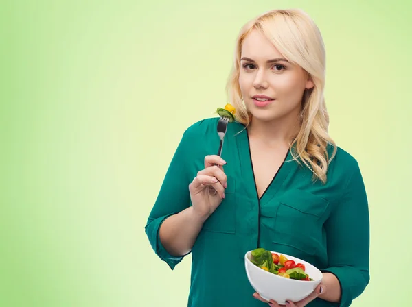 Souriant jeune femme manger salade de légumes — Photo