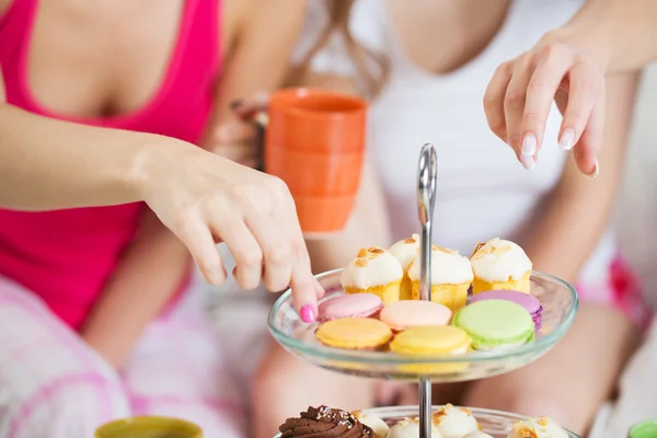 Freunde oder Teenie-Mädchen, die zu Hause Süßigkeiten essen — Stockfoto