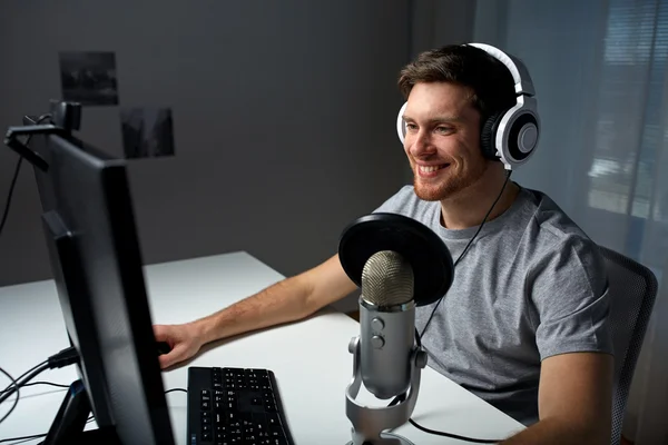 Ο άνθρωπος σε ακουστικά που παίζει το παιχνίδι γραφικών του υπολογιστή στο σπίτι — Φωτογραφία Αρχείου