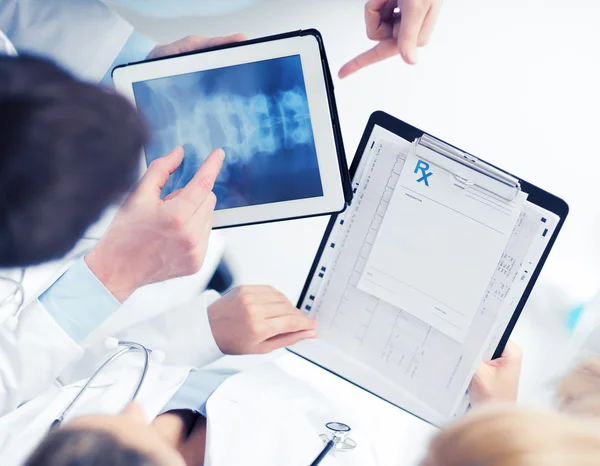 Groep van artsen kijken x-ray op tablet pc — Stockfoto