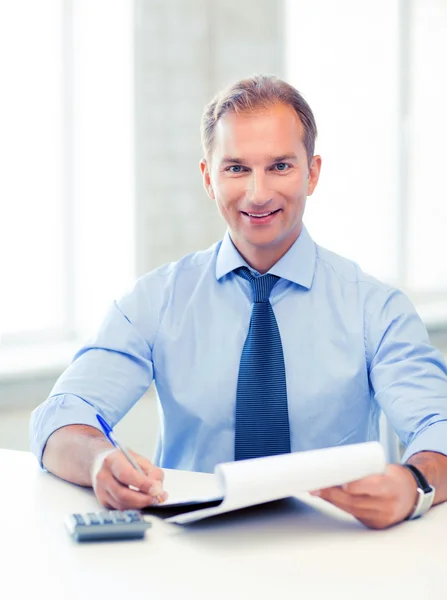 Empresario con cuaderno y calculadora — Foto de Stock