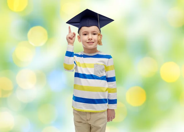 Niño feliz en sombrero de soltero señalando el dedo hacia arriba — Foto de Stock