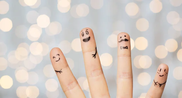 Gros plan de quatre doigts avec des visages souriants — Photo