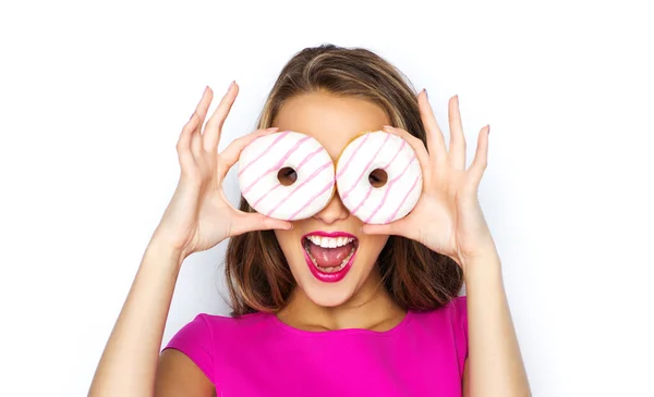 Mulher feliz ou menina adolescente olhando através de donuts — Fotografia de Stock