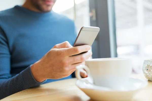 Primer plano del hombre con teléfonos inteligentes en la cafetería — Foto de Stock