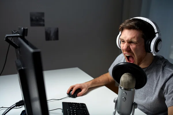 Homem em fone de ouvido jogando jogo de computador em casa — Fotografia de Stock