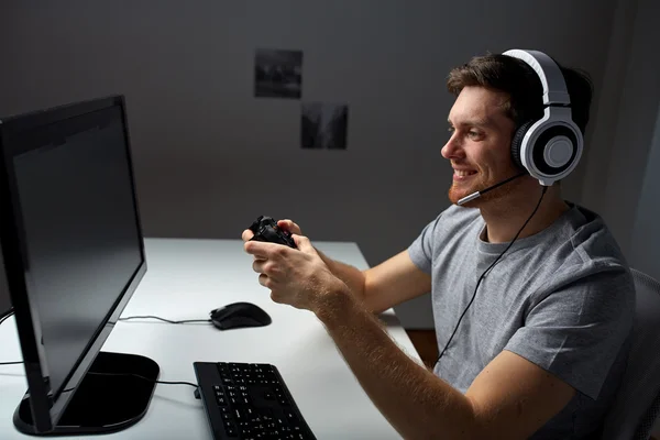 Uomo in cuffia giocare al videogioco per computer a casa — Foto Stock