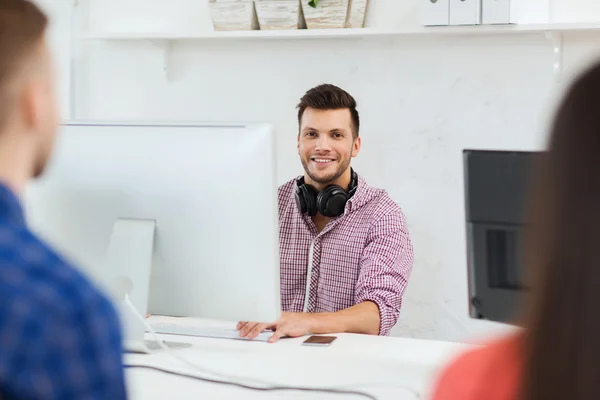 En lykkelig ung mann eller student med data på kontoret – stockfoto