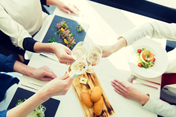 Close up of women clinking champagne at restaurant — Stock Photo, Image