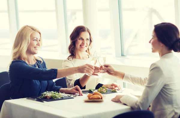 Glada kvinnor dricka champagne på restaurang — Stockfoto