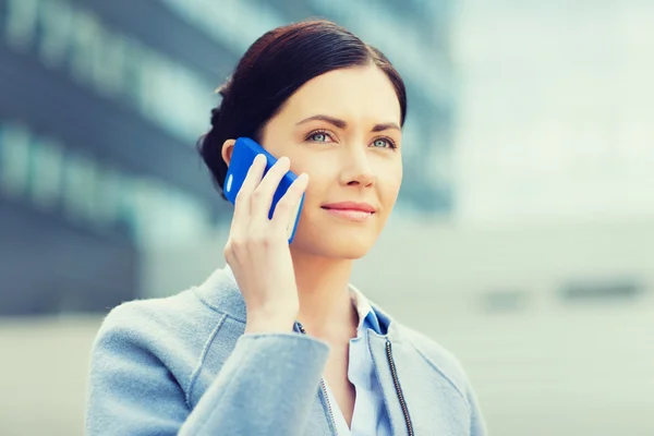 Молодая улыбающаяся деловая женщина звонит на смартфон — стоковое фото
