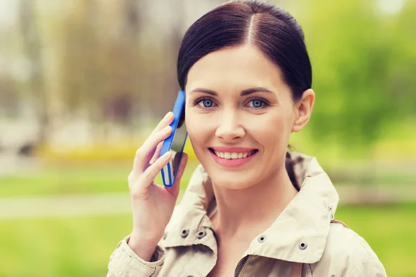 Donna sorridente che chiama sullo smartphone nel parco — Foto Stock