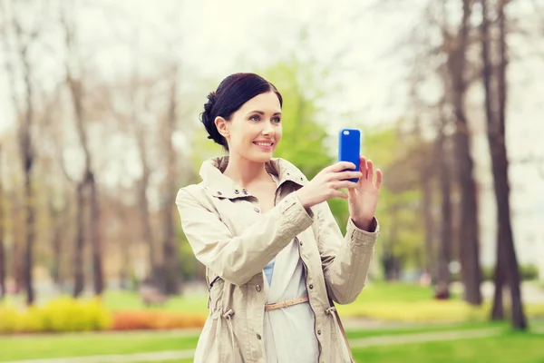 Femme souriante prenant des photos avec smartphone — Photo