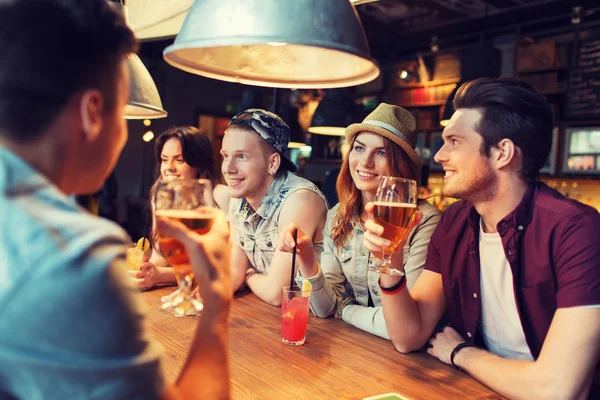 Glada vänner med drycker pratar på baren eller pub — Stockfoto