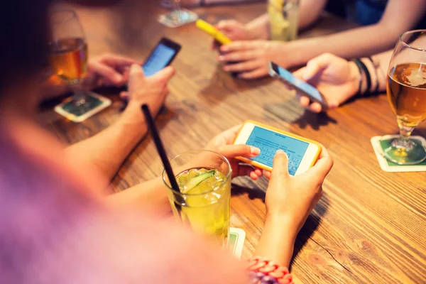 Close up de mãos com smartphones no restaurante — Fotografia de Stock