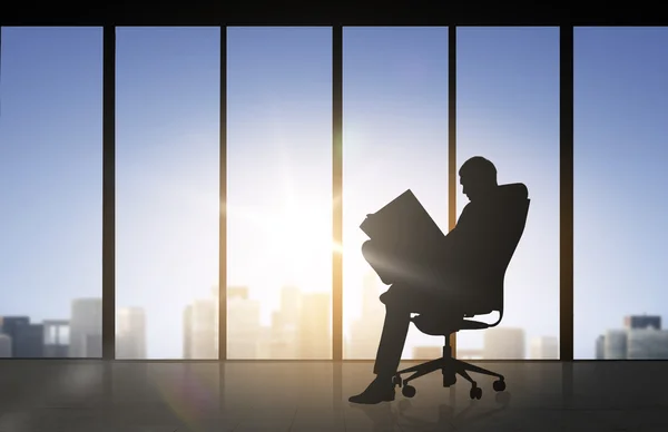 Silhouette of businessman reading documents — 图库照片