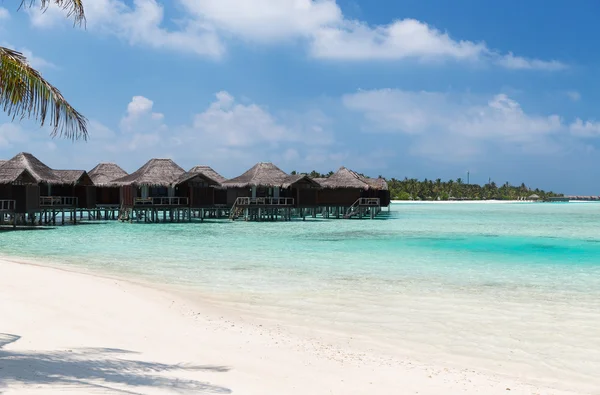 Bungalow huts i havsvatten på exotiska resort beach — Stockfoto