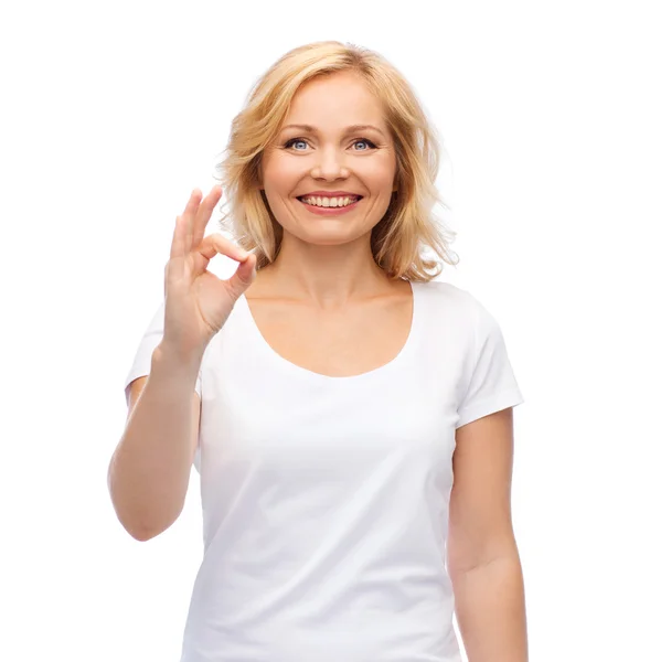 Gelukkige vrouw in wit t-shirt met o.k. hand teken — Stockfoto