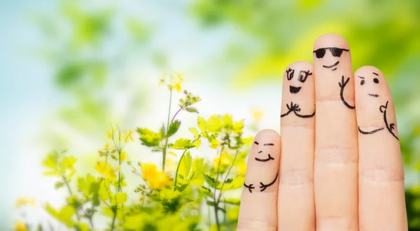 Close up of fingers with smiley faces over nature — Stock Photo, Image