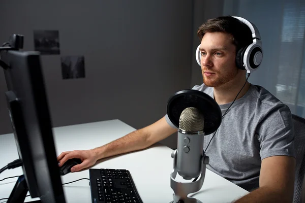 man in headset playing computer video game at home