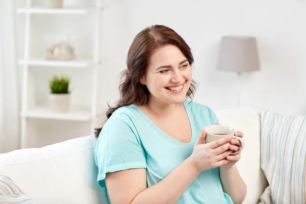 Mujer feliz más tamaño con taza de té en casa — Foto de Stock