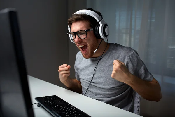 自宅でコンピューターのビデオ ゲームをプレイのヘッドセットで男 — ストック写真