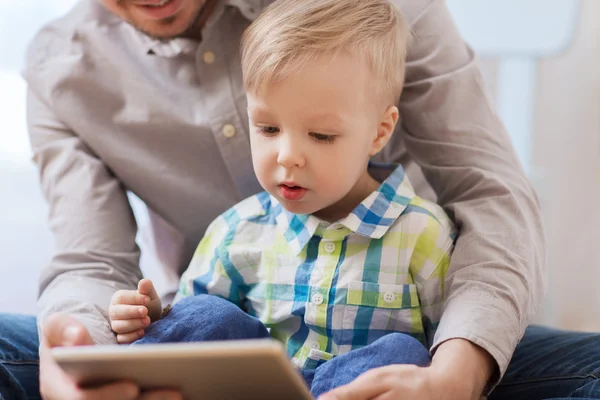 Pai e filho com tablet pc jogando em casa — Fotografia de Stock