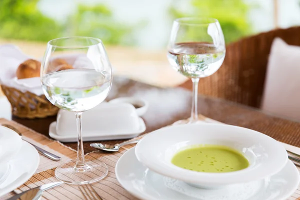 Close up of soup and water glasses at restaurant — Stock Photo, Image