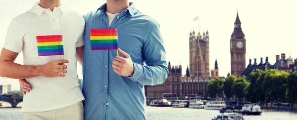 Close up of male gay couple with rainbow flags — Stock Photo, Image
