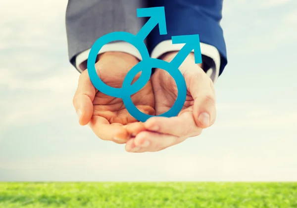 Close up of male gay couple holding gender symbol — Stock Photo, Image