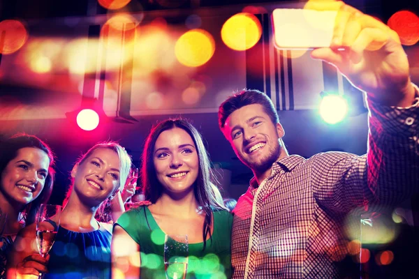 Friends taking selfie by smartphone in night club — Stock Photo, Image