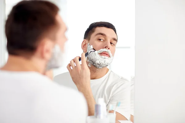 Barba de barbear homem com lâmina de barbear no banheiro — Fotografia de Stock